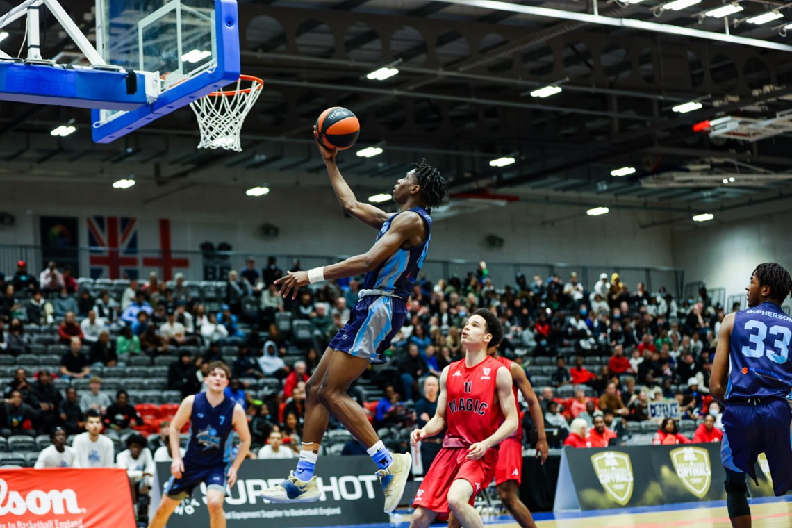 A photograph of a basketball player making a lay up